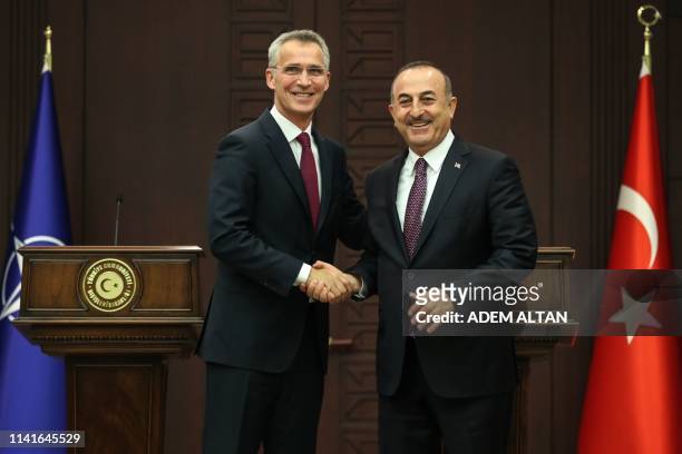 Turkish Foreign Minister Mevlut Cavusoglu shakes hands with NATO Secretary General Jens Stoltenberg during a joint press conference at Cankaya Palace...
