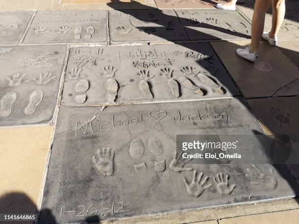 tourist visiting footprint and hand prints of superstar at graumans tcl chinese theater in hollywood, los angeles, california usa - hollywood boulevard stock pictures, royalty-free photos & images