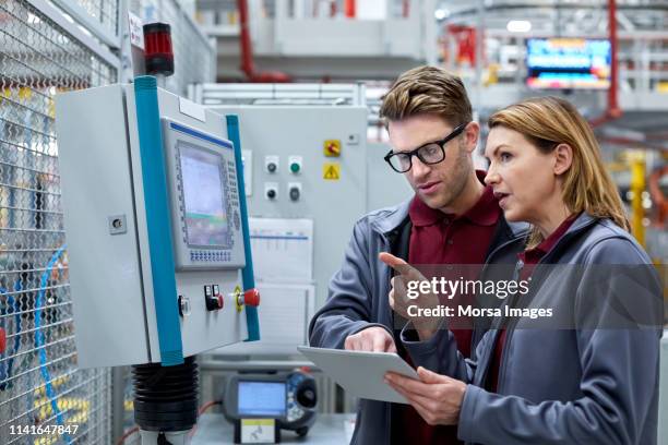 auto-ingenieure mit tablet-computer wegschauen - factory engineer woman stock-fotos und bilder