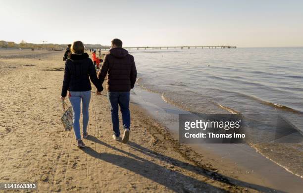 Young couple walking on the Baltic Sea Beach pictured on April 21, 2019 on Heringsdorf, Germany.
