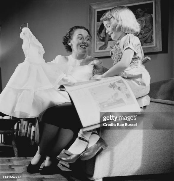 Little girl gets her 'dream' dress handmade and tailored by a dressmaker at a McCall Pattern Company shop, US, circa 1950.