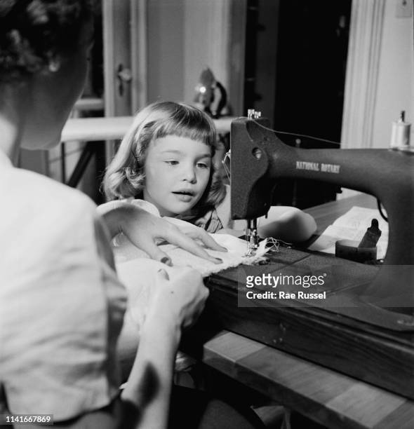 Little girl gets her 'dream' dress handmade and tailored by a dressmaker at a McCall Pattern Company shop, US, circa 1950.