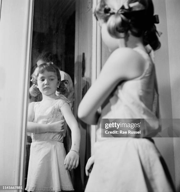 Little girl gets her 'dream' dress handmade and tailored by a dressmaker at a McCall Pattern Company shop, US, circa 1950.