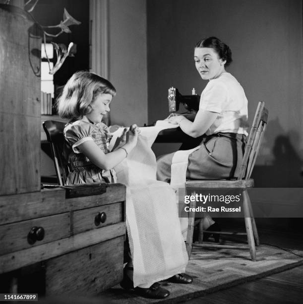 Little girl gets her 'dream' dress handmade and tailored by a dressmaker at a McCall Pattern Company shop, US, circa 1950.