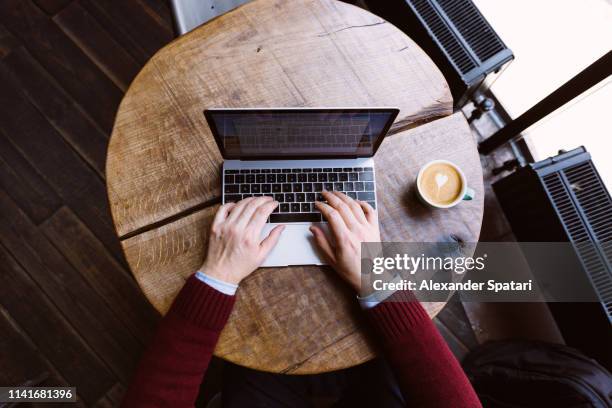 directly above view of a man working on laptop in coffee shop, personal perspective view - persoonlijk perspectief stockfoto's en -beelden