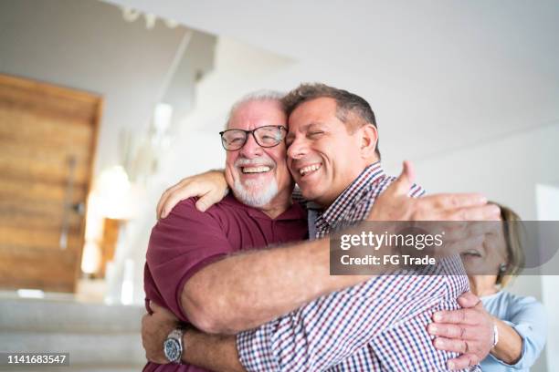 son and father embracing - grandpa son stock pictures, royalty-free photos & images