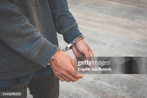 Arrested businessman handcuffed hands. Close-up. Arrested businessman handcuffed hands. Close-up.