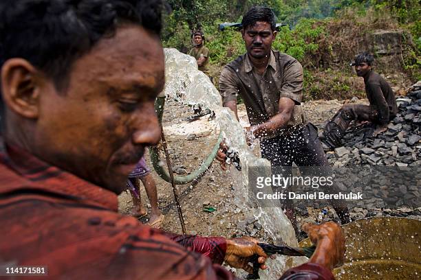 Coal miners wash themselves off as they break for lunch at a coal mine on April 13, 2011 near the village of Latyrke near Lad Rymbai, in the district...