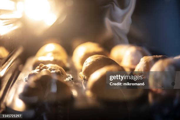 woman preparing muffins and putting it into oven - pastry imagens e fotografias de stock