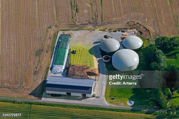 Aerial view over anaerobic digestion plant showing digesters with inflatable biogas holders, Schleswig-Holstein, Germany.