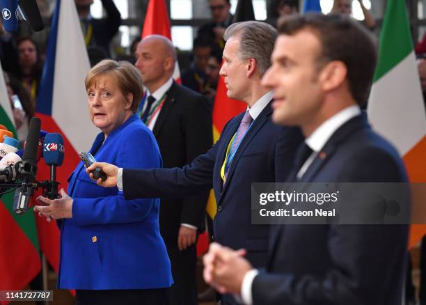 Germany's Chancellor Angela Merkel looks back at French President Emmanuel Macron as they speak to the media ahead of a European Council meeting on...