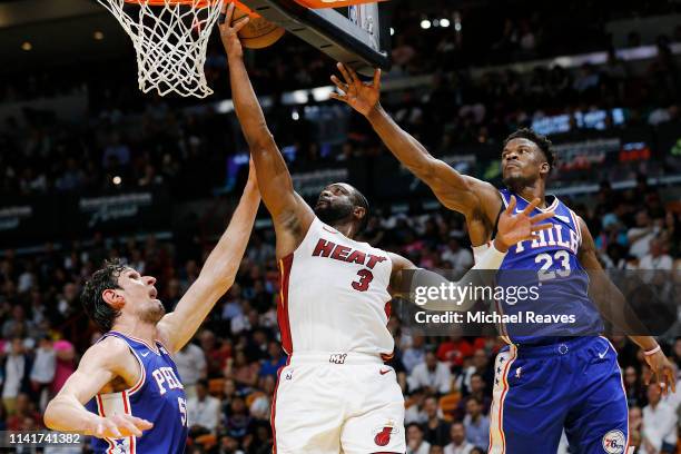 Dwyane Wade of the Miami Heat attempts a layup against Jimmy Butler and Boban Marjanovic of the Philadelphia 76ers during the first half at American...