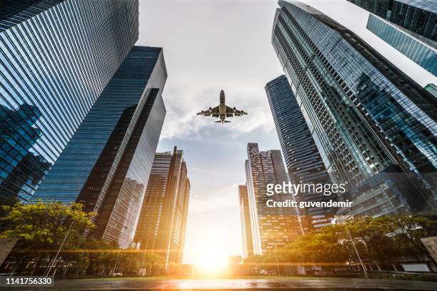 シンガポールの中央ビジネス街を飛ぶ飛行機 - aircraft skyscrapers ストックフォトと画像