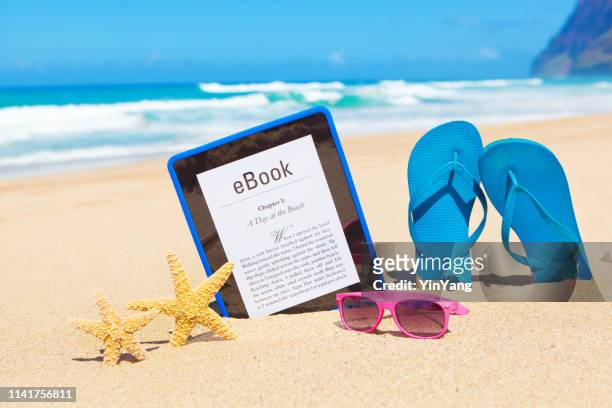 novela de lectura de verano americana en e-reader digital tablet computer en la playa - lector de libros electrónicos fotografías e imágenes de stock
