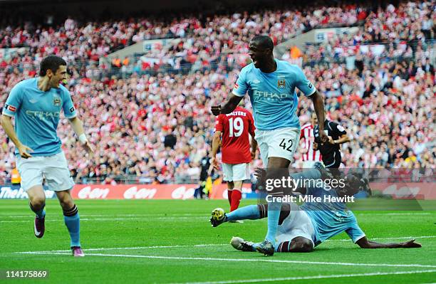 Yaya Toure of Manchester City celebrates as team mate Mario Balotelli tries to trip him up after he scored during the FA Cup sponsored by E.ON Final...