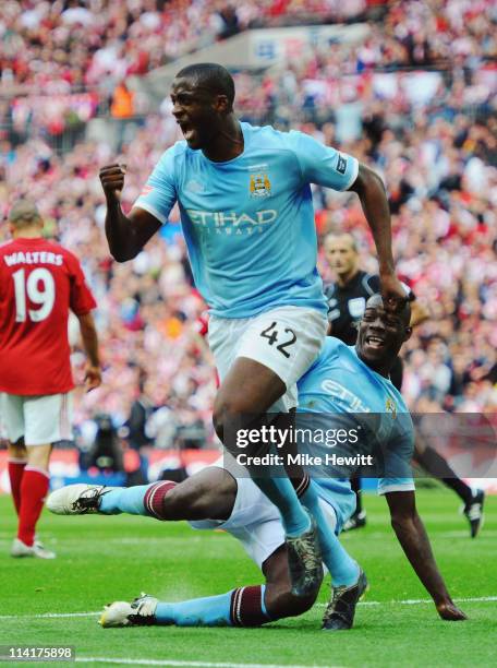 Yaya Toure of Manchester City celebrates as team mate Mario Balotelli tries to trip him up after he scored during the FA Cup sponsored by E.ON Final...