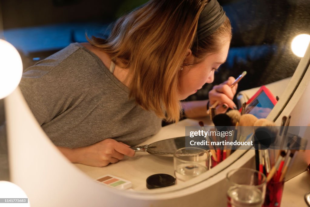 Millenial kvinna gör make-up efter en tutorial.