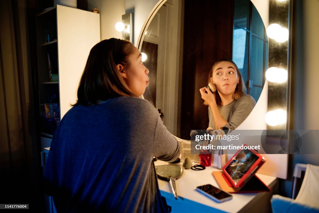 Millenial woman doing make-up following a tutorial.