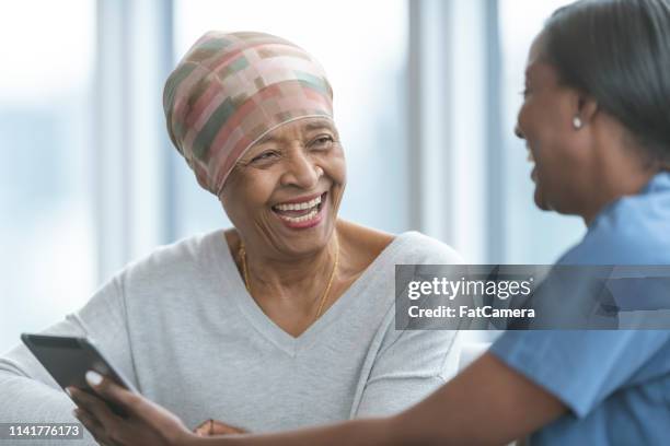 Senior woman with cancer reviews test results with female doctor