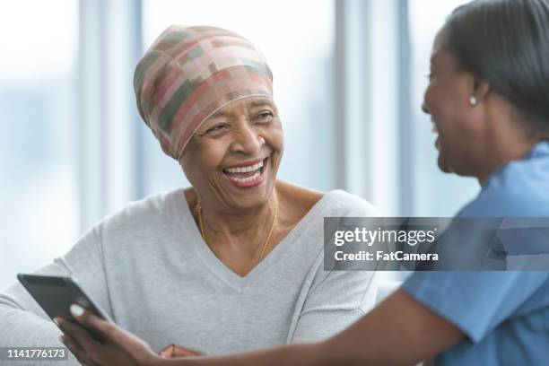 senior woman with cancer reviews test results with female doctor - mammogram stock pictures, royalty-free photos & images