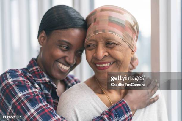 courageous woman with cancer spends precious time with adult daughter - cancer illness stock pictures, royalty-free photos & images
