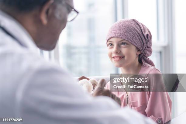 癌との勇敢な女の子は医者と会う - leukemia ストックフォトと画像