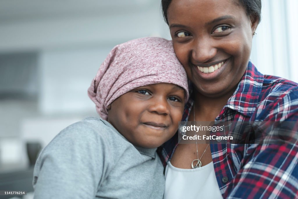 Supportive mother holds child with cancer