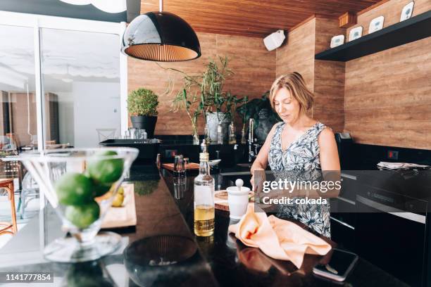senior woman preparing traditional brazilian drink caipirinha - cachaça stock pictures, royalty-free photos & images