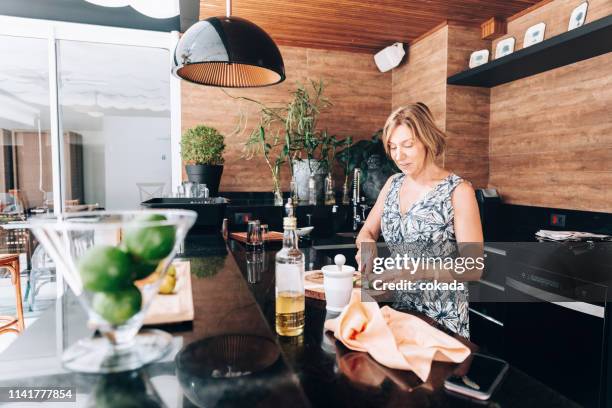 senior woman preparing traditional brazilian drink caipirinha - outdoor kitchen stock pictures, royalty-free photos & images