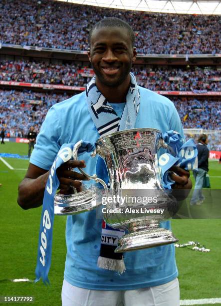 Yaya Toure holds the trophy after he and his Manchester City team mates won the FA Cup sponsored by E.ON Final match between Manchester City and...