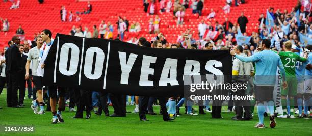 Manchester City team carry a banner as they celebrate winning their first trophy since 1976 during the FA Cup sponsored by E.ON Final match between...