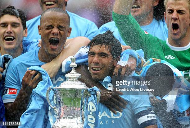 Carlos Tevez of Manchester City and his team mates celebrate with the trophy after they won the FA Cup sponsored by E.ON Final match between...