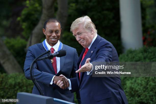 President Donald Trump gives professional golfer and business partner Tiger Woods the Medal of Freedom during a ceremony in the Rose Garden at the...