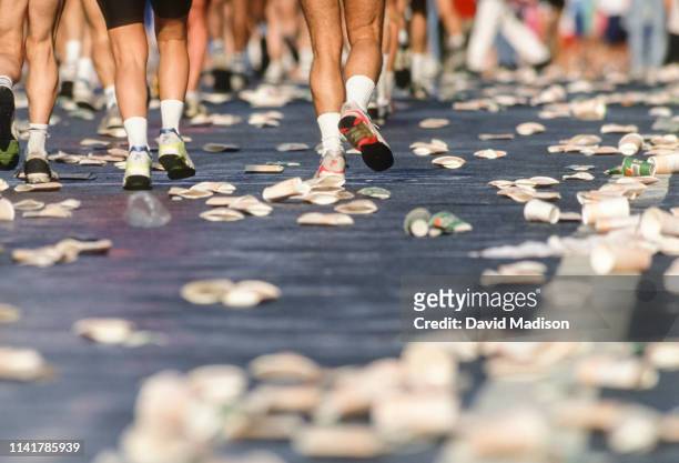 Runners competing in the 1991 New York City Marathon run through discarded drink cups on First Avenue in Manhattan near the midway point of the race...