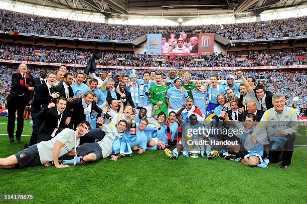 In this handout image provided by The FA, the Man City squad celebrate with the trophy after their 1-0 victory during the The FA Cup sponsored by...