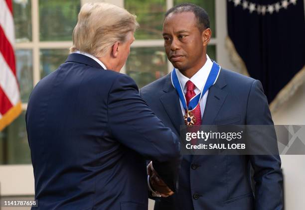 President Donald Trump presents US golfer Tiger Woods with the Presidential Medal of Freedom during a ceremony in the Rose Garden of the White House...