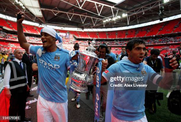 Vincent Kompany and Carlos Tevez of Manchester City celebrate with the trophy following the FA Cup sponsored by E.ON Final match between Manchester...