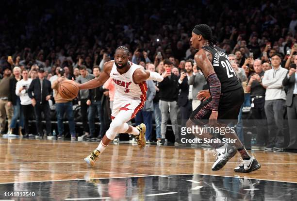 Dwyane Wade of the Miami Heat dribbles against Rondae Hollis-Jefferson of the Brooklyn Nets during final seconds of the game against the Brooklyn...