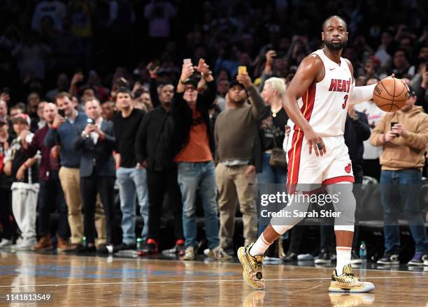 Dwyane Wade of the Miami Heat dribbles the ball in the final seconds of the game against the Brooklyn Nets at Barclays Center on April 10, 2019 in...