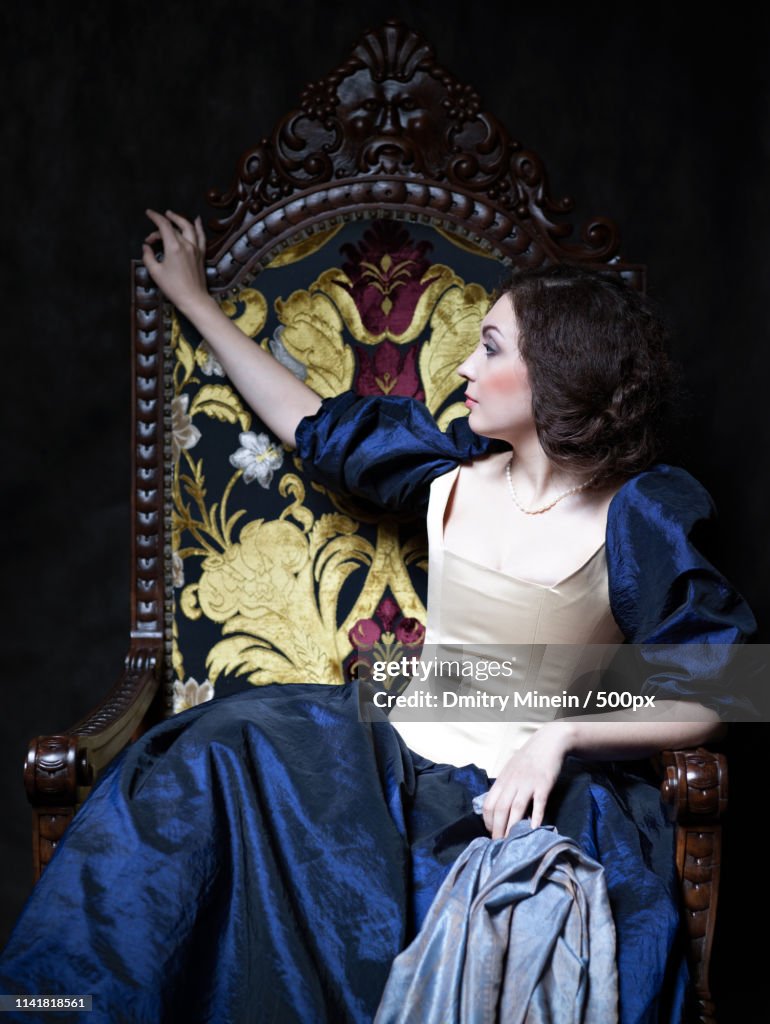 Close up portrait of woman in 17th century dress sitting in chair