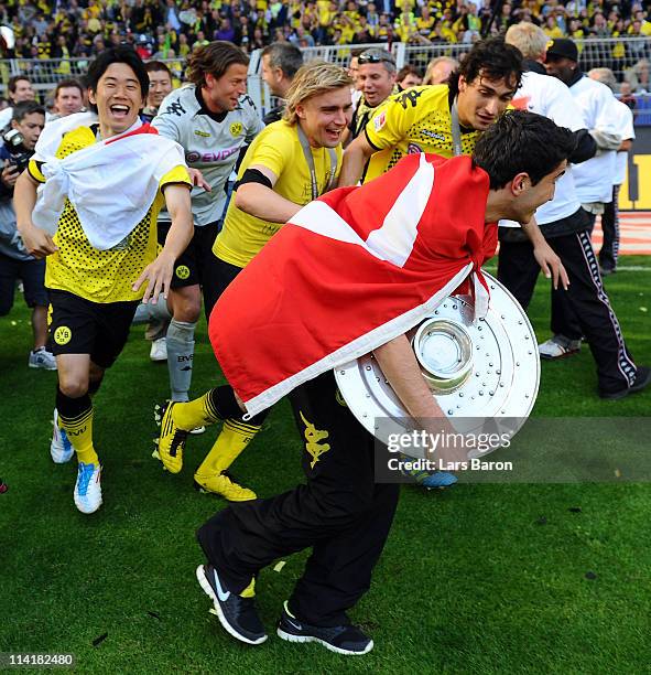 Nuri Sahin of Dortmund runs away with the trophy next to his team mates Shinji Kagawa, Marcel Schmelzer and Mats Hummels after the Bundesliga match...