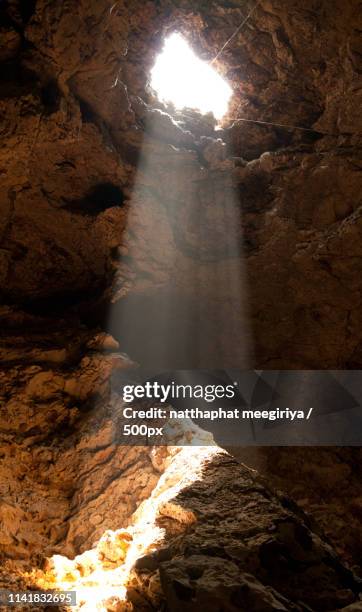 the orange light through hole in the cave - dungeon opening foto e immagini stock