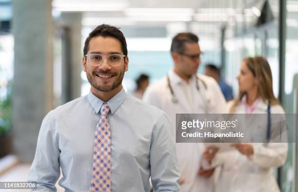 successful hospital supervisor looking at camera smiling - doctor recruitment stock pictures, royalty-free photos & images