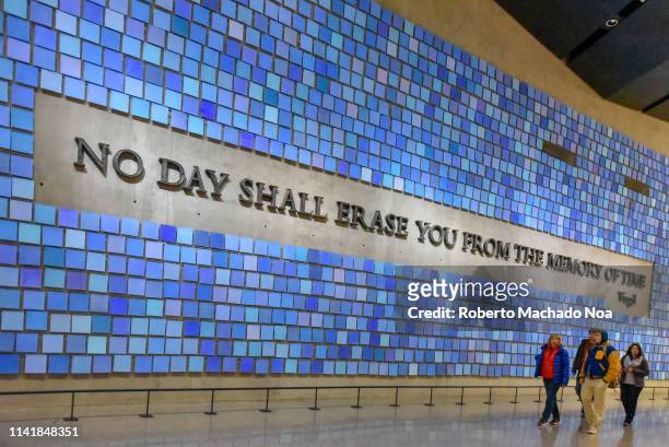 Inside of the National September 11 Memorial and Museum. Entrance detail. Blue wall with text reading: No Day Shall Erase You From the Memory of Time.