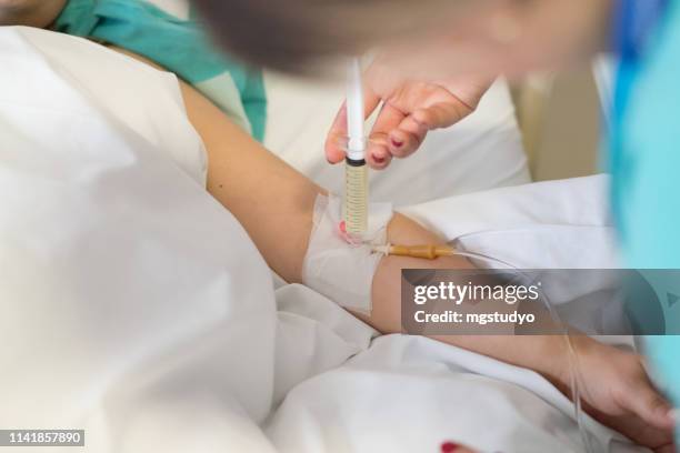 nurse doing injection to patient after surgery - injecting iv stock pictures, royalty-free photos & images