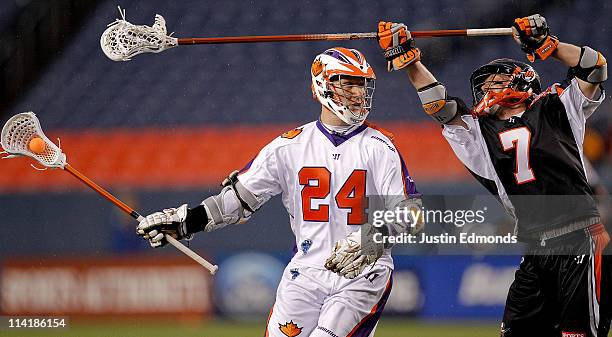 John Grant Jr. #24 of Hamilton Nationals controls the ball away from Matt Bocklet of Denver Outlaws during the season opener at INVESCO Field at Mile...