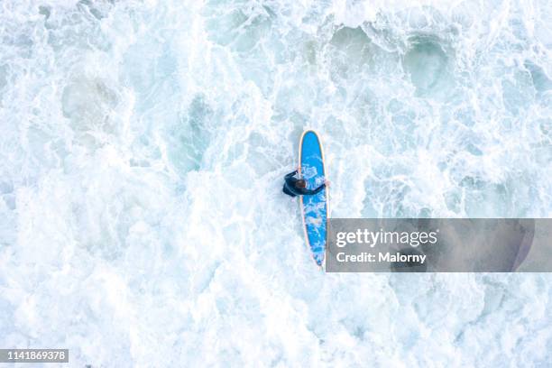 aerial view or drone view on young man with surfboard in wavy sea. - extreme foto e immagini stock