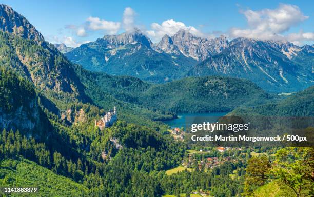 mountainpanorama with neuschwanstein - schwangau stockfoto's en -beelden