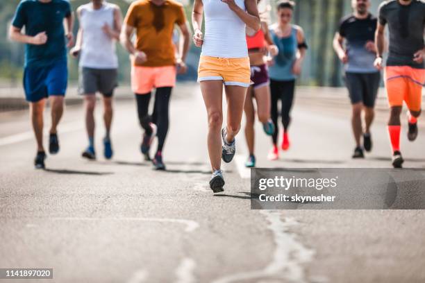 grande grupo de corredores de maratona irreconhecível que têm uma raça na estrada. - meia maratona - fotografias e filmes do acervo