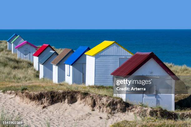 Row of colourful beach cabins in the dunes at Gouville-sur-Mer, Lower Normandy, France.